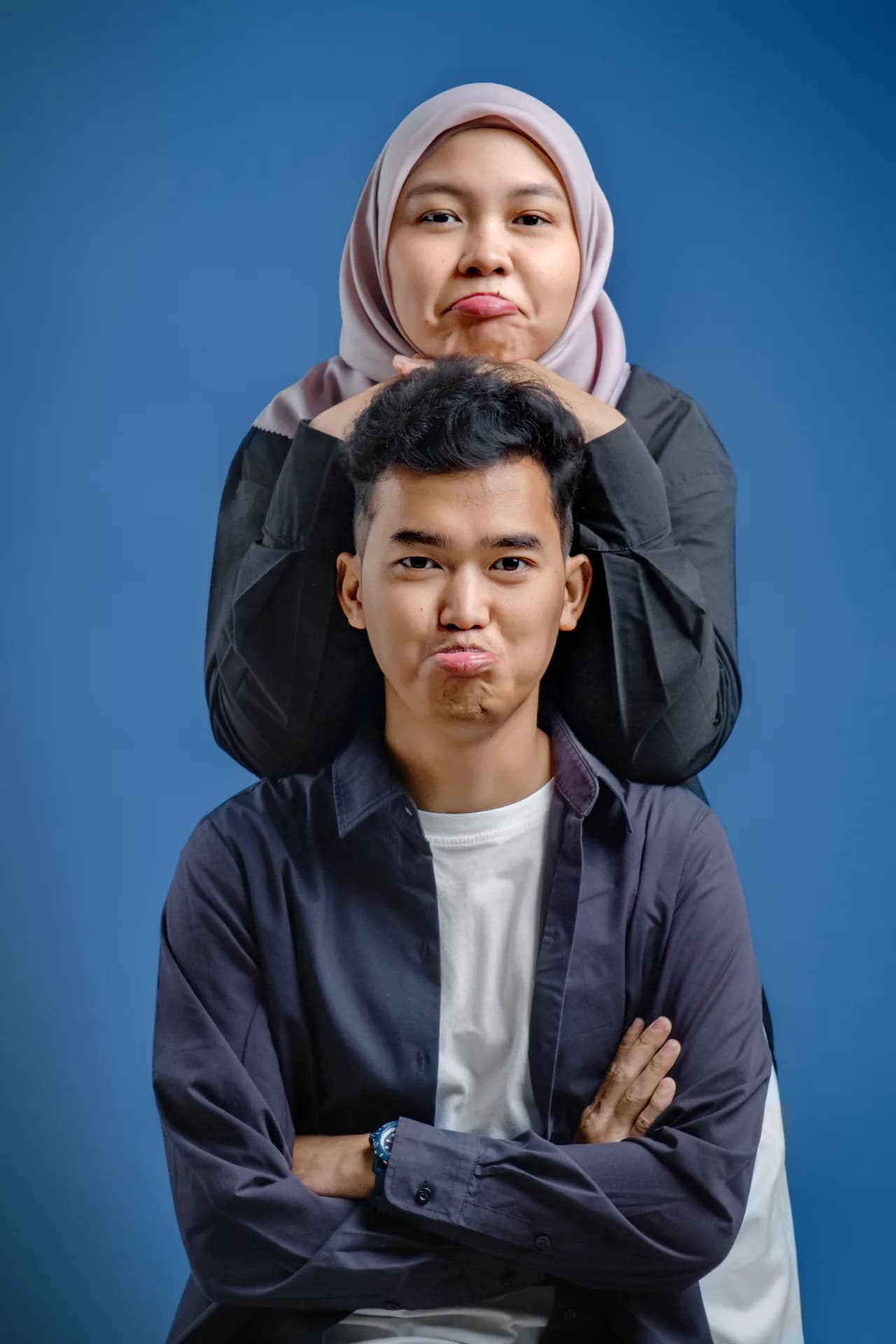 Alfi dan Ifa berpose ceria berlatar biru